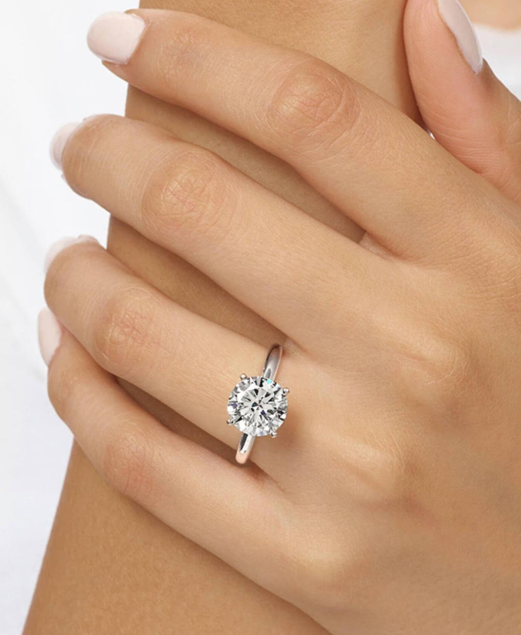 Diamond ring on a hand against a white background