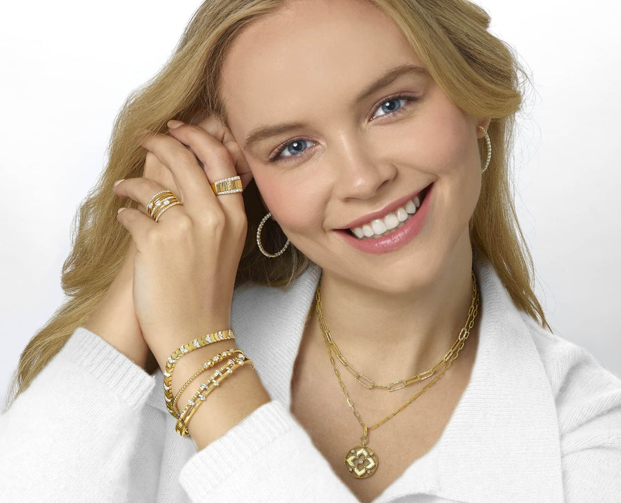 Woman wearing gold and diamond jewelry on a white background