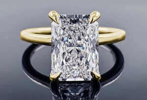 Gold ring with a large diamond on a reflective surface