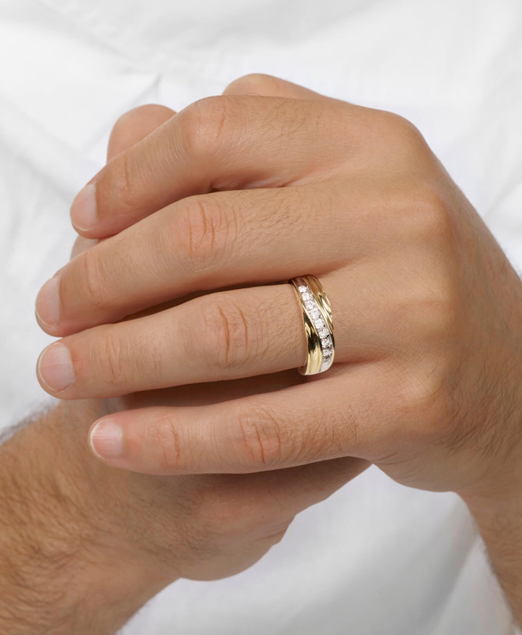 Hand wearing a gold ring with a white background